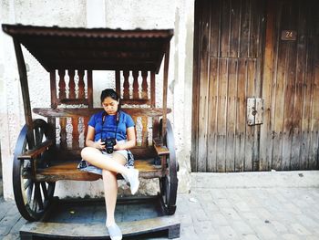 Portrait of boy sitting on door