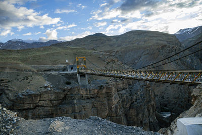 Bridge over rocks against sky