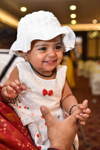 Portrait of happy girl holding hat