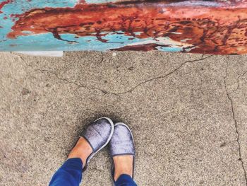 Low section of woman standing on footpath