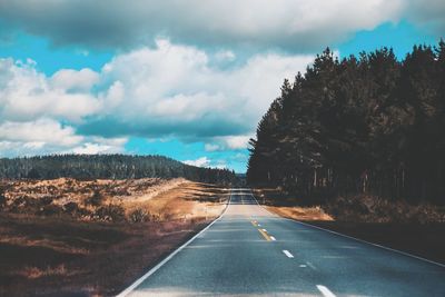 Road amidst trees against sky