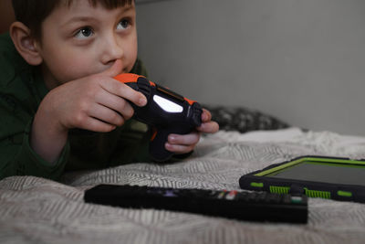 Kids playing video games at home on the bed at night. boys using game console and having fun in the