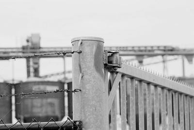 Close-up of railing against bridge against clear sky