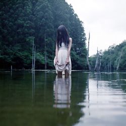 Rear view of man standing by lake