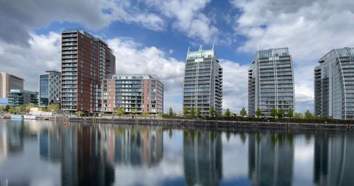 Reflection of buildings in city against sky