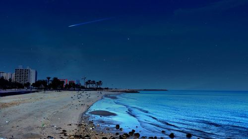 Scenic view of beach against blue sky at night