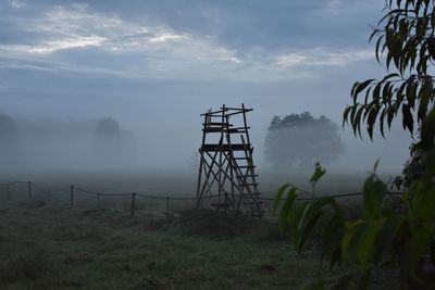 Silhouette trees on field against sky