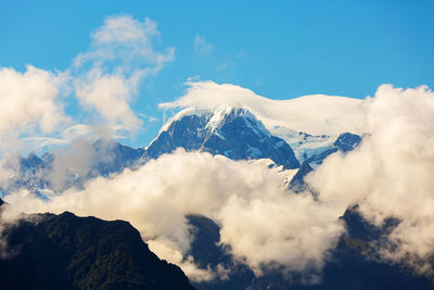 Low angle view of snowcapped mountains against sky