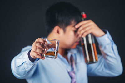 Midsection of man drinking glass