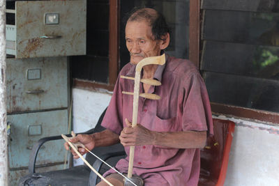 An old man plays a musical instrument in tehyan.