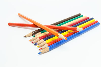 High angle view of colored pencils against white background