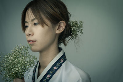 Portrait of young woman against white background