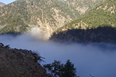 Scenic view of trees and mountains against sky