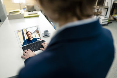 Businesswoman working with colleague on video call through digital tablet in industry