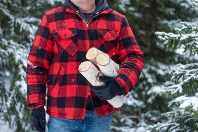 Low section of person standing on snow covered forest