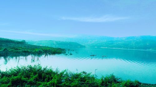 Scenic shot of calm countryside lake against blue sky