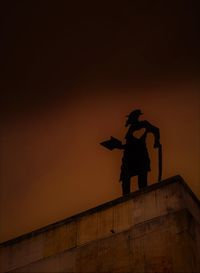 Low angle view of silhouette statue against sky during sunset