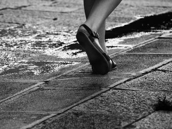 Low section of woman walking on road