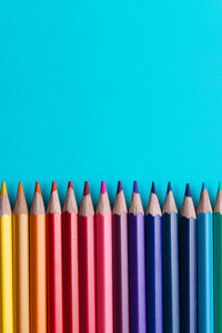 Close-up of multi colored pencils against blue background