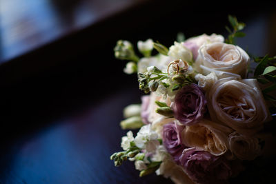 Close-up of wedding rings on rose bouquet