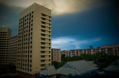 Buildings in city against cloudy sky