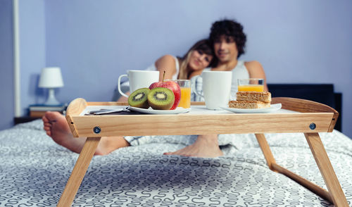 Woman eating food on table at home