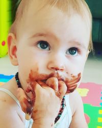 Close-up of cute baby girl eating chocolate