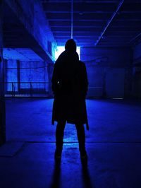 Rear view of silhouette woman standing in illuminated corridor