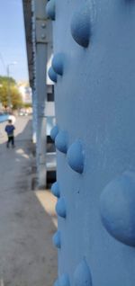Close-up of snow in city against blue sky