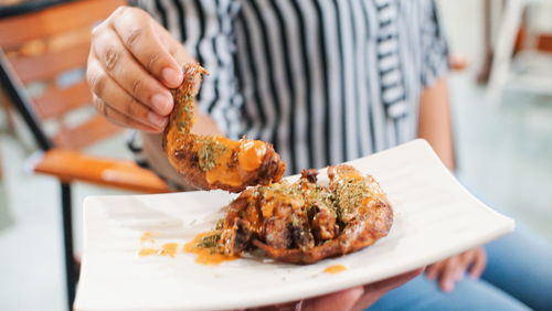 Midsection of woman holding food in plate