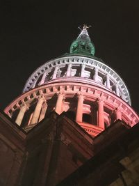 Low angle view of statue of illuminated building against sky at night