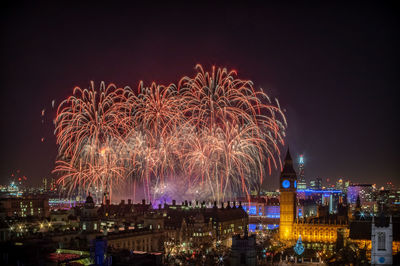 High angle view of firework display at night