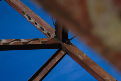 Low angle view of metallic structure against blue sky