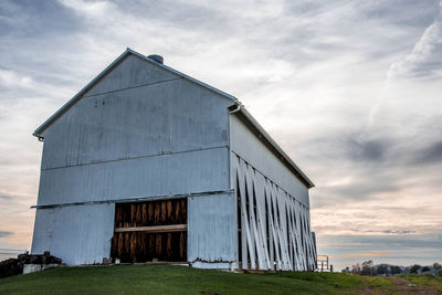 Barn on field against sky