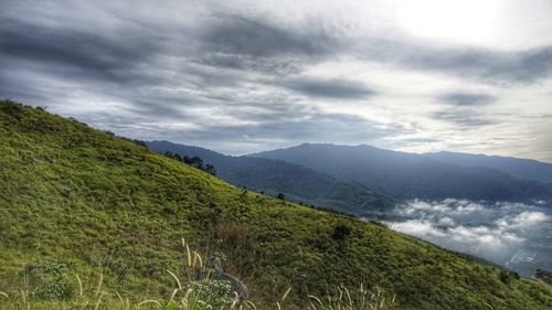 Scenic view of mountains against cloudy sky