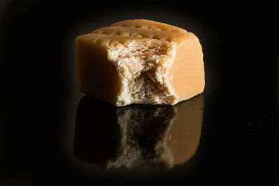 Close-up of bread on table against black background