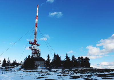 Low angle view of communications tower against sky during winter