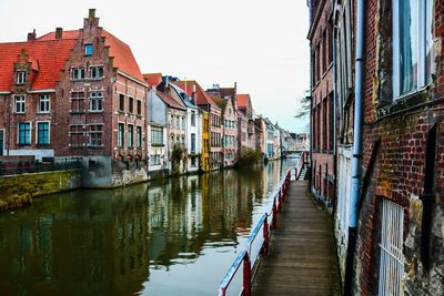 Canal amidst buildings against sky in city