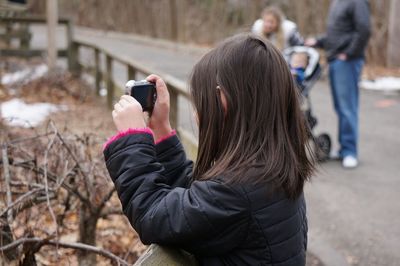 Rear view of woman photographing