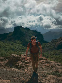 Full length of man hiking on mountain against sky