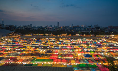 Illuminated cityscape against sky at night