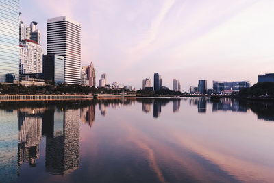 Reflection of buildings in city at sunset