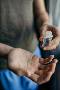 Midsection of man holding hand sanitizer