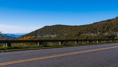 Road by mountains against blue sky