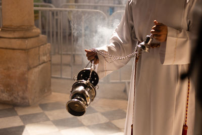 Priest waves incense during mass for santa luzia at pilar church in the city of salvador, bahia.