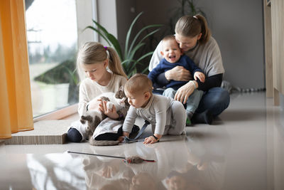 A mother with her  children playing on the floor at home during quarantine corona virus covid-19