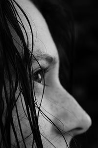 Close-up of woman looking away against black background