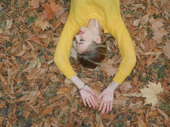 High angle view of girl lying down on autumn leaves