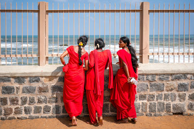 Rear view of people standing against the wall