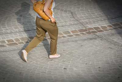 Low section of woman walking on footpath